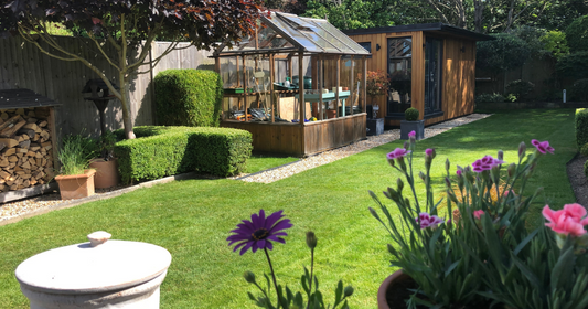 GreenThumb healthy green lawn with greenhouse and flowers bordering lawn