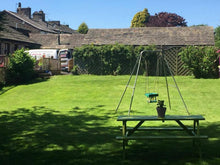 A garden table and childrens swing on a lawn treated by GreenThumb Burnley