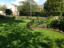 lush lawn surrounded by plants and flowers treated by GreenThumb Wharfedale